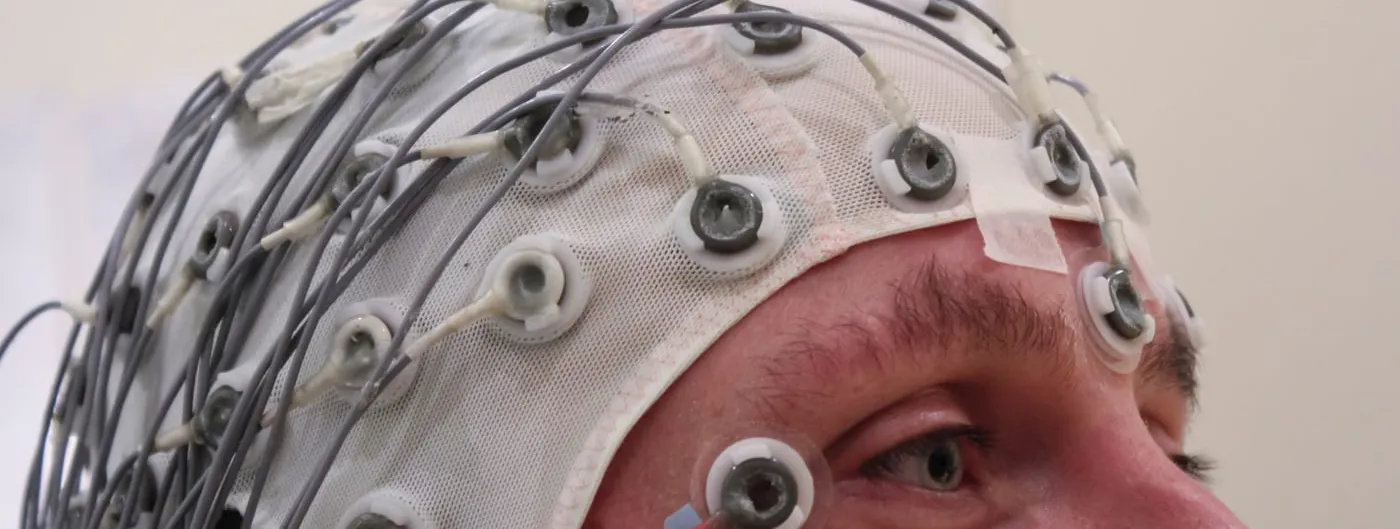A cap holding an array of electrodes against a person’s scalp during an EEG recording session.