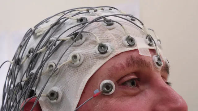 A cap holding an array of electrodes against a person’s scalp during an EEG recording session.