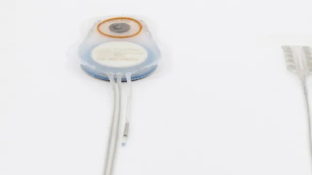 A round implantable device wrapped in translucent mesh, its white centre label reading CorTec Brain Interchange BIC, with three thin lead wires trailing from the lower edge and the end of a flat electrode array visible at the right of the frame.