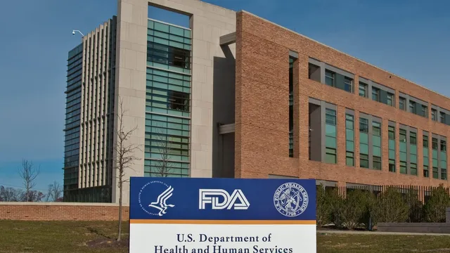 The blue-and-white US Department of Health and Human Services and FDA entrance sign standing in front of FDA Building 21 at the White Oak campus.
