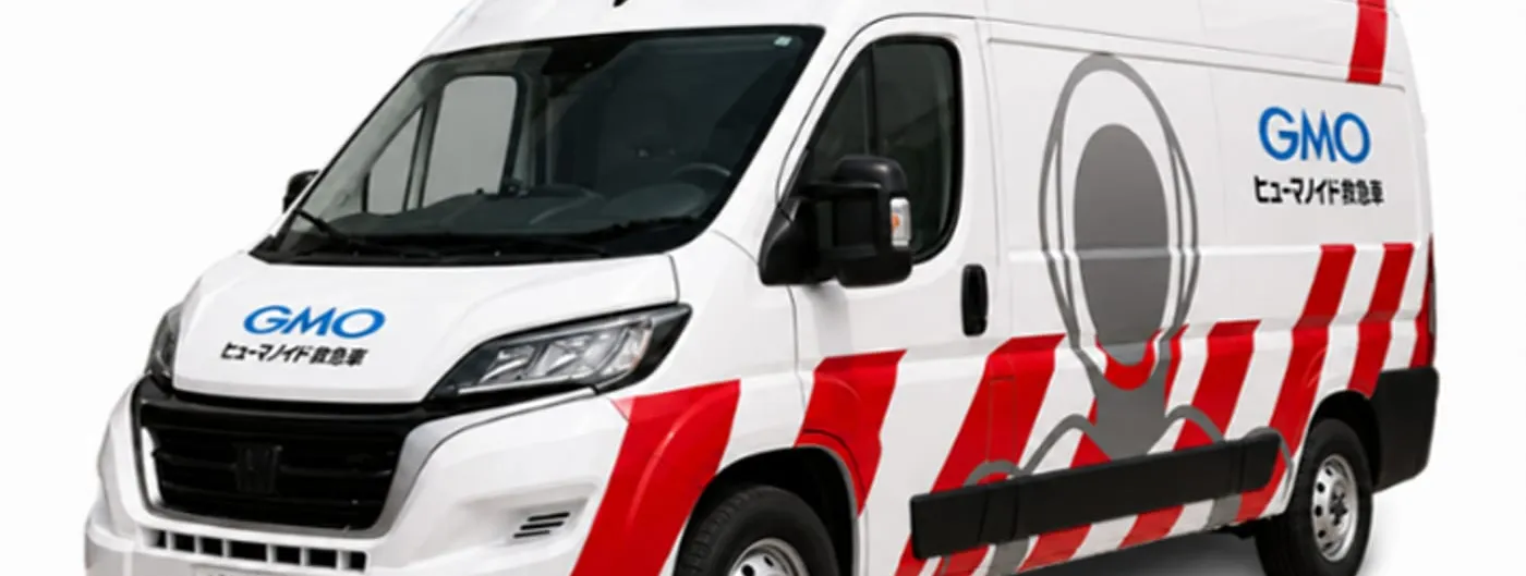 A white high-roof van marked with red hazard stripes, a blue light bar and a grey humanoid figure painted on its side panel, photographed against a plain background.
