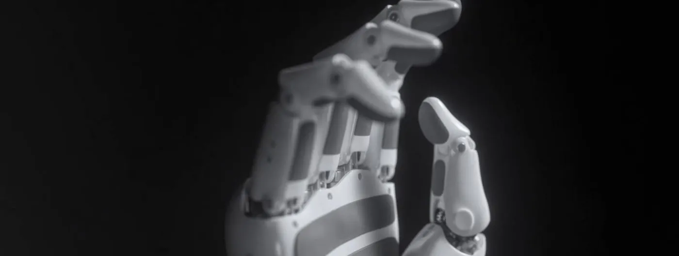 A close-up of Kinetix AI's KAI Hand, a multi-fingered dexterous robotic hand with articulated white and grey joints, held upright against a black background.