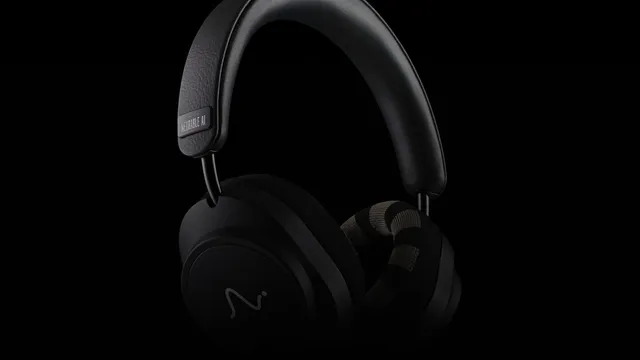 Black over-ear headphones with a leather headband and knit-fabric ear cushions, photographed in low-key lighting against a black background, with a Neurable AI plate on the headband.