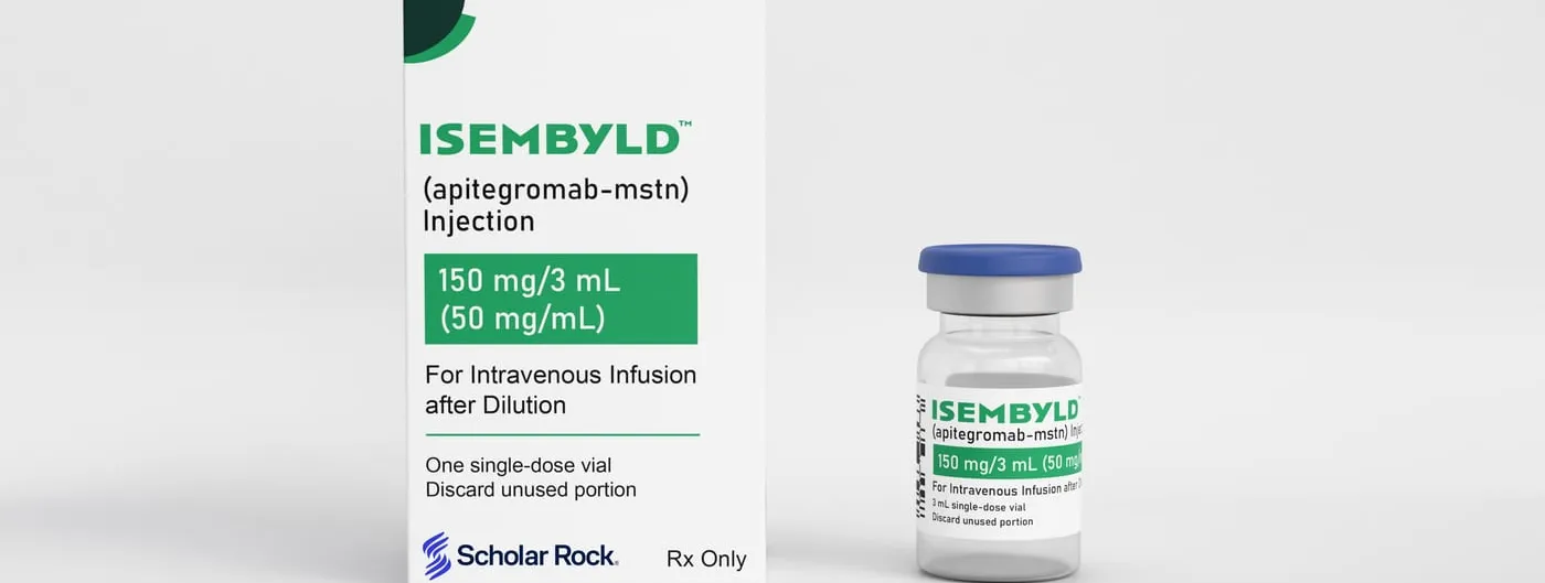 A carton and a glass vial of Scholar Rock's ISEMBYLD injection stand side by side on a white studio background, labelled as an illustration rather than an actual product photograph.