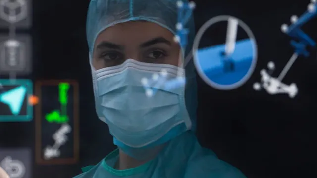 A masked surgeon in a green cap and gown looks through a navigation display overlaid with tracked instrument outlines and a segmented vertebra view.