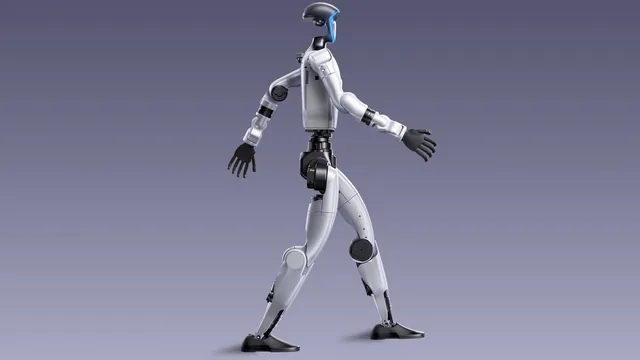 A silver and black humanoid robot with a visored head and dark hands walks in mid-stride against a plain purple-grey studio background.