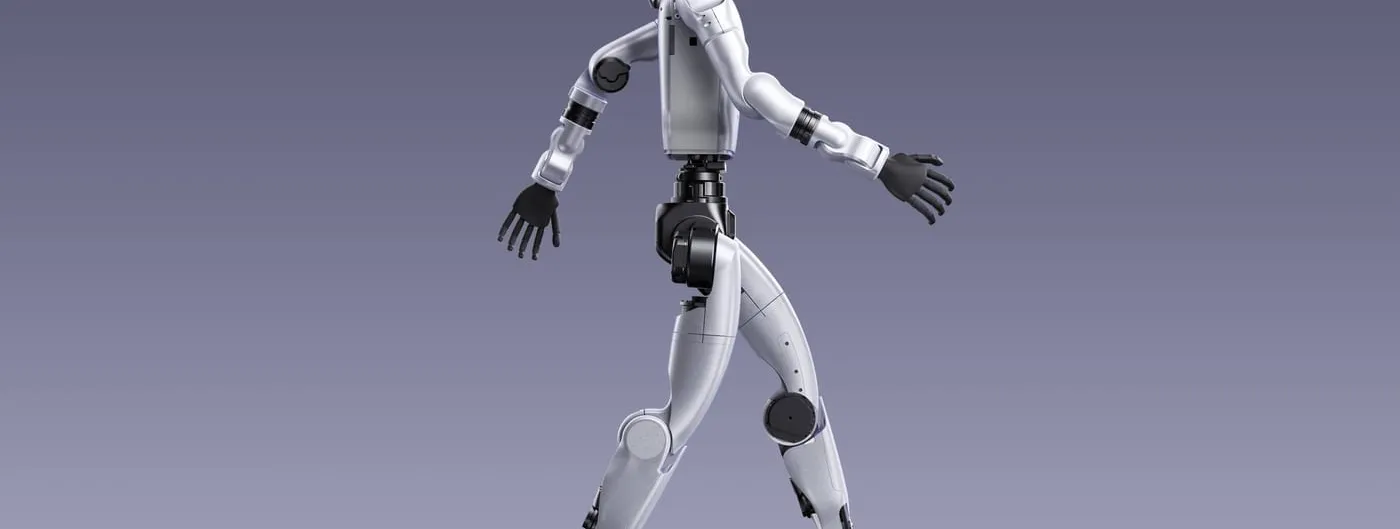 A silver and black humanoid robot with a visored head and dark hands walks in mid-stride against a plain purple-grey studio background.